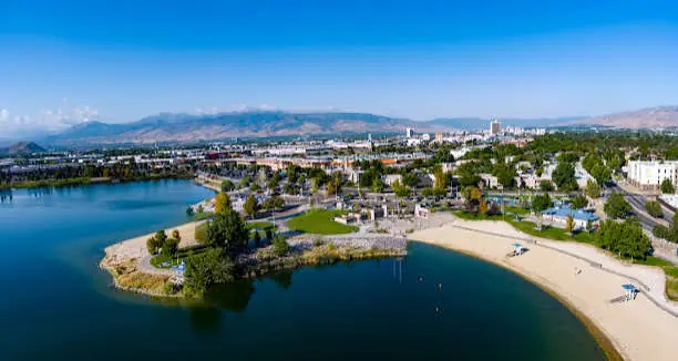 Aerial view of Sparks Marina beach, waterfront park, and nearby commercial district in Sparks, NV, with clear blue sky